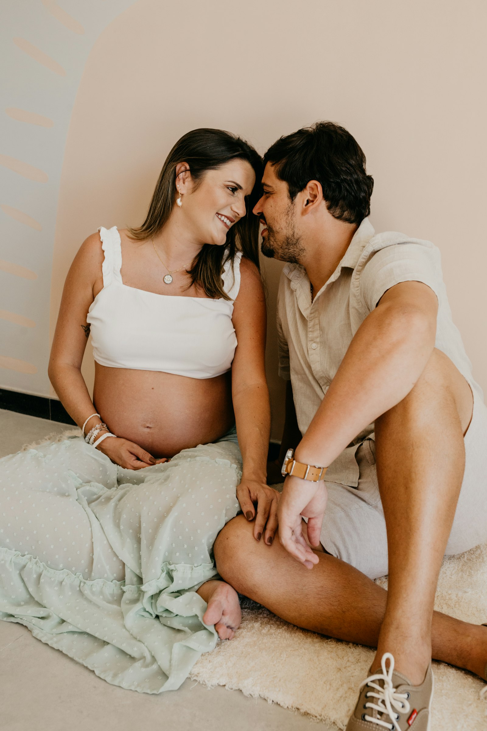 An expecting couple sitting together at home